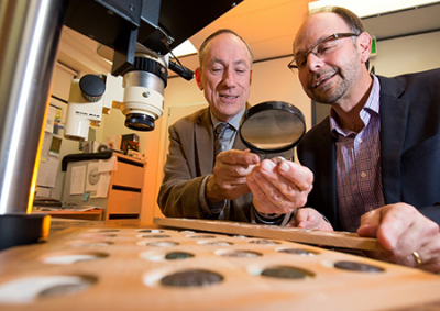 Associate Professor Kenneth Sheedy and Dr Gil Davis examine ancient coins. 肯尼斯•西迪的照片,吉尔·戴维斯研究古代硬币。
