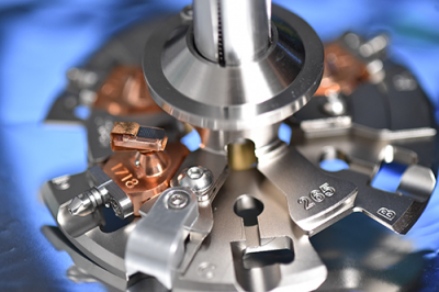Microtip arrays are placed into copper pucks (shown labelled 1718) and then loaded onto carousels that are then placed in the instrument for analysis. Material experiments rely on the principle of field evaporation, whereby a strong electric field is applied to the sharply pointed specimen sufficient to cause removal of atoms by ionisation. (Photo: US Naval Research Laboratory/Jamie Hartman) Microtip数组放入铜妖精(1718年标签所示),然后装上旋转木马,然后放置在仪器进行分析。材料试验依赖于场蒸发的原理,即应用于强电场急剧指出标本足以引起原子被电离作用。(照片:美国海军研究实验室/杰米·哈特曼)