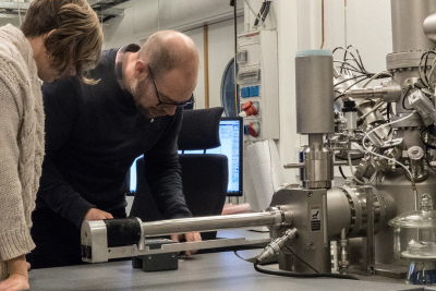 Chemists Lina Hagvall and Per Malmberg prepare samples for analysis in the time-of flight secondary ion mass spectrometer (ToF-SIMS). During analysis the samples are inserted into the test chamber using the test arm shown at the bottom of the picture. Credit: Mats Tiborn
